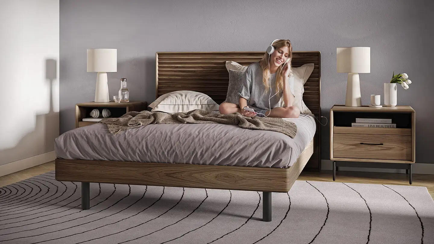 Young adult enjoying listening to music on her new BDI Linq bed from Niu Urban Living in South Texas.