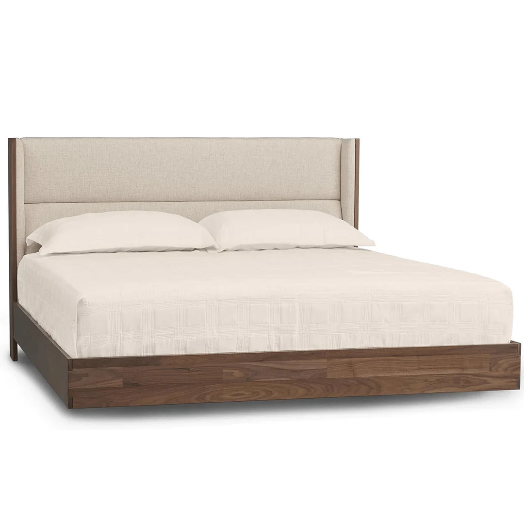 sloane1 Modern floating walnut platform bed with upholstered headboard in a cream fabric.