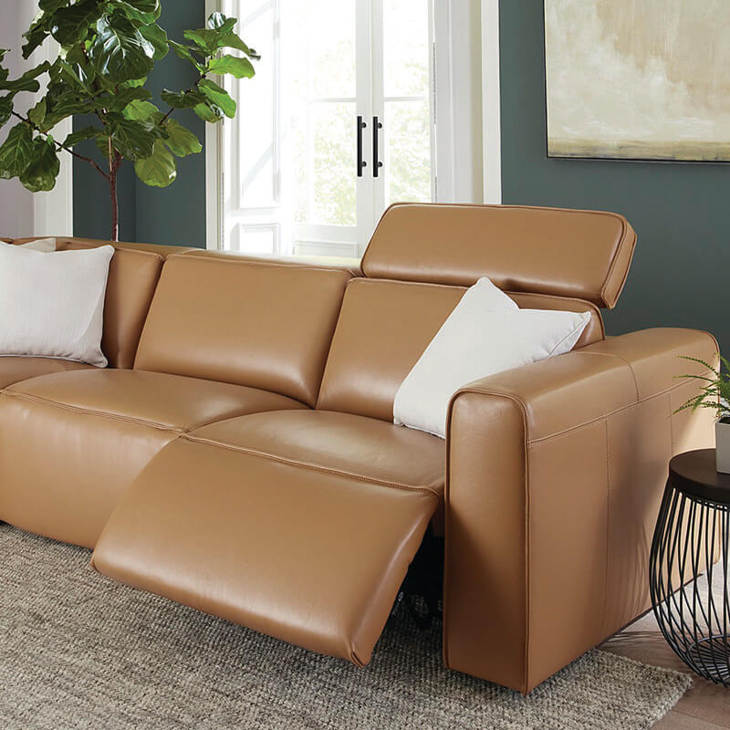 camel colored leather reclining sofa chaise with reclining seat position shown staged with white cushions