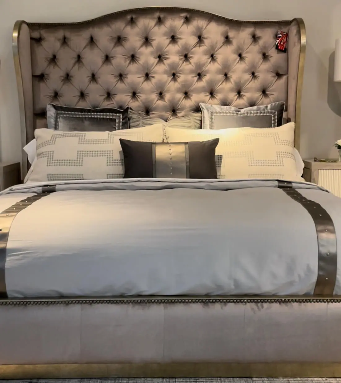 a traditional bed with the tufted headboard in a purplish fabric